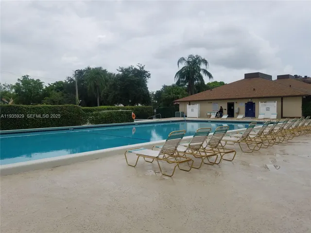 a group of lawn chairs sitting under a large umbrella