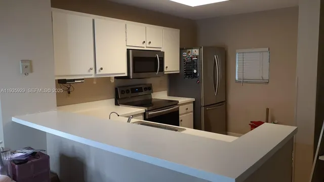 a kitchen with stainless steel appliances a stove microwave and sink
