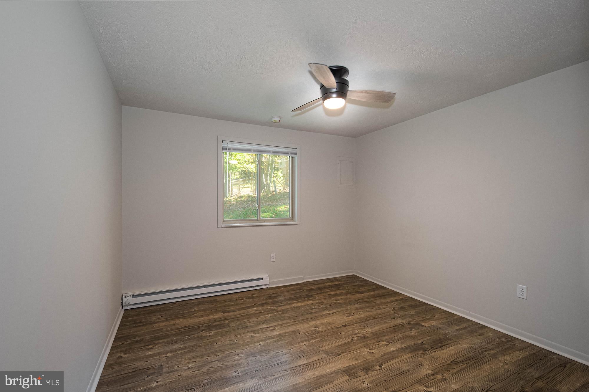 1724 Mosser Road, Unit 1 McHenry, MD 21541 - Photo 9 of 24 an empty room with wooden floor and ceiling fan