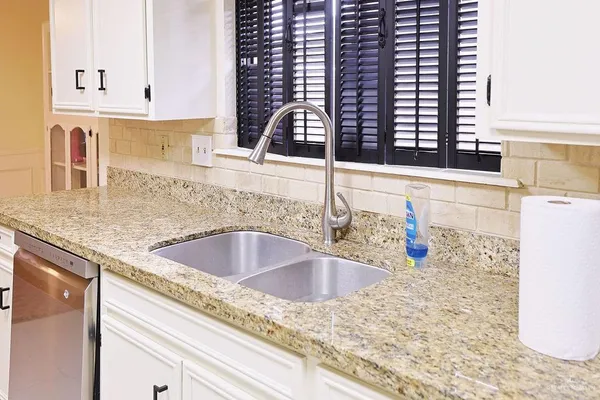 a kitchen with granite countertop a sink and a stove