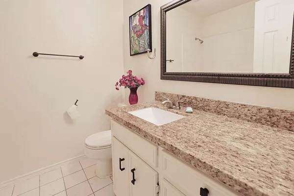 a bathroom with a granite countertop sink and a mirror