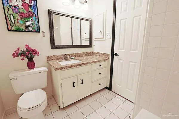 a bathroom with a toilet sink vanity and mirror