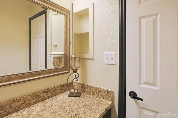 a bathroom with a granite countertop sink and a mirror