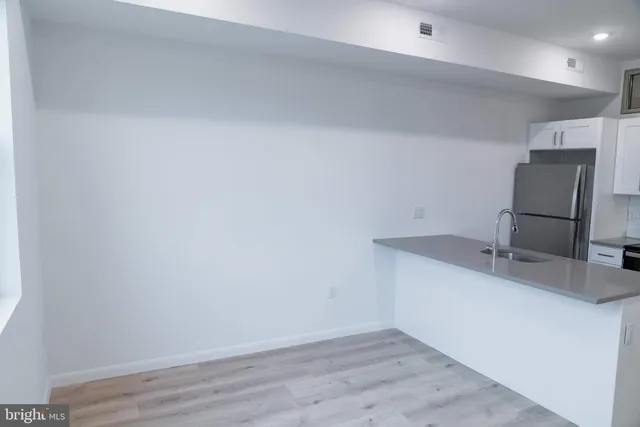 an empty room with a sink and mirror