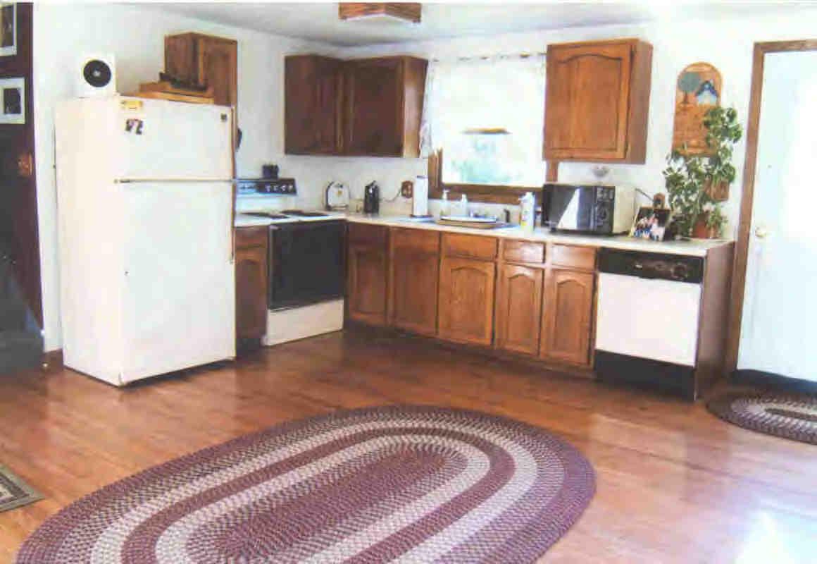 41 Chestnut Hill Road Monterey, MA 01245 - Photo 2 of 4 a kitchen with a refrigerator sink and white cabinets