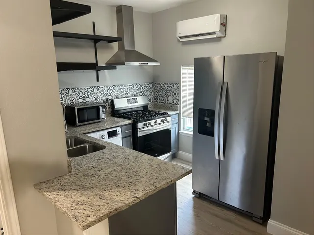 a kitchen with stainless steel appliances granite countertop a refrigerator and a sink