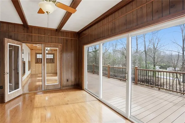a view of a hallway with wooden floor and windows