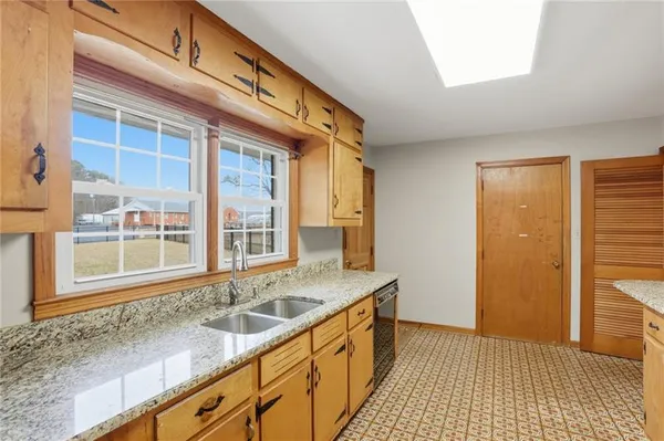 a large kitchen with stainless steel appliances granite countertop a sink and cabinets