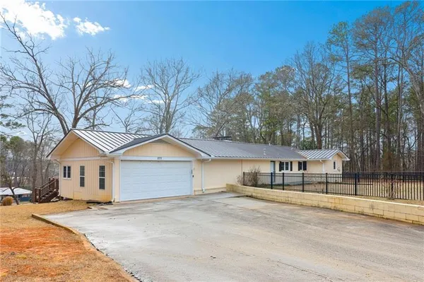 a front view of a house with a garden and tree