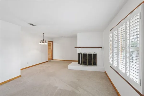 a view of an empty room with a fireplace and a window