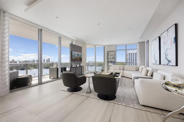 a living room with furniture a large window and kitchen view