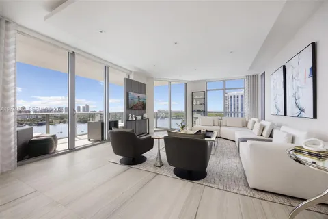 a living room with furniture a large window and kitchen view