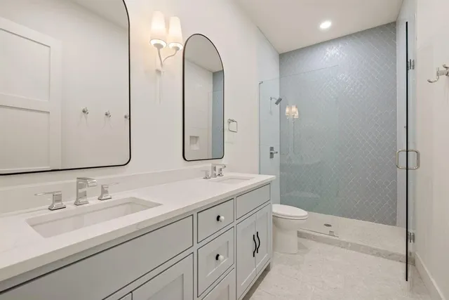 a bathroom with a double vanity sink toilet and shower
