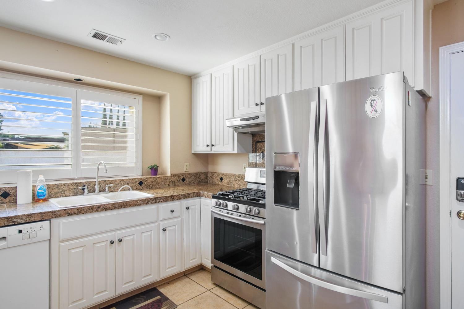 1345 Alex Circle Turlock, CA 95382 - Photo 16 of 35 a kitchen with stainless steel appliances white cabinets and a refrigerator