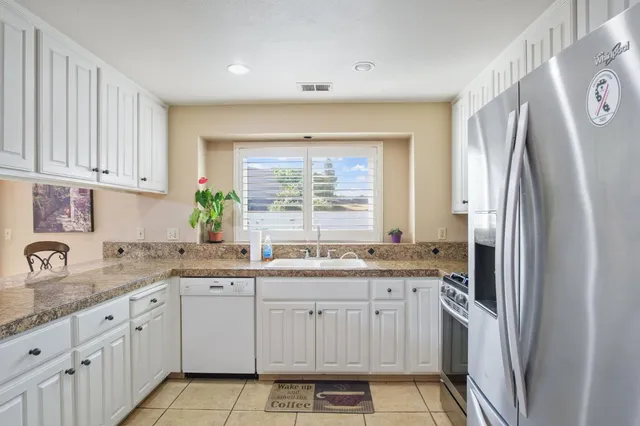 a kitchen with granite countertop a sink stove and refrigerator