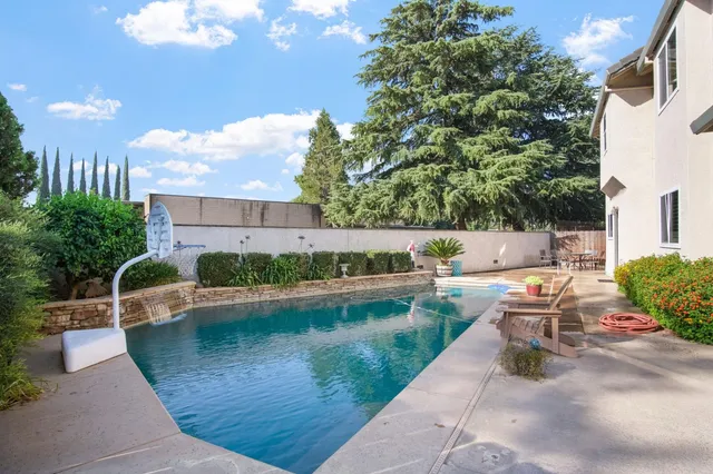 a view of a patio with couches table and chairs and potted plants