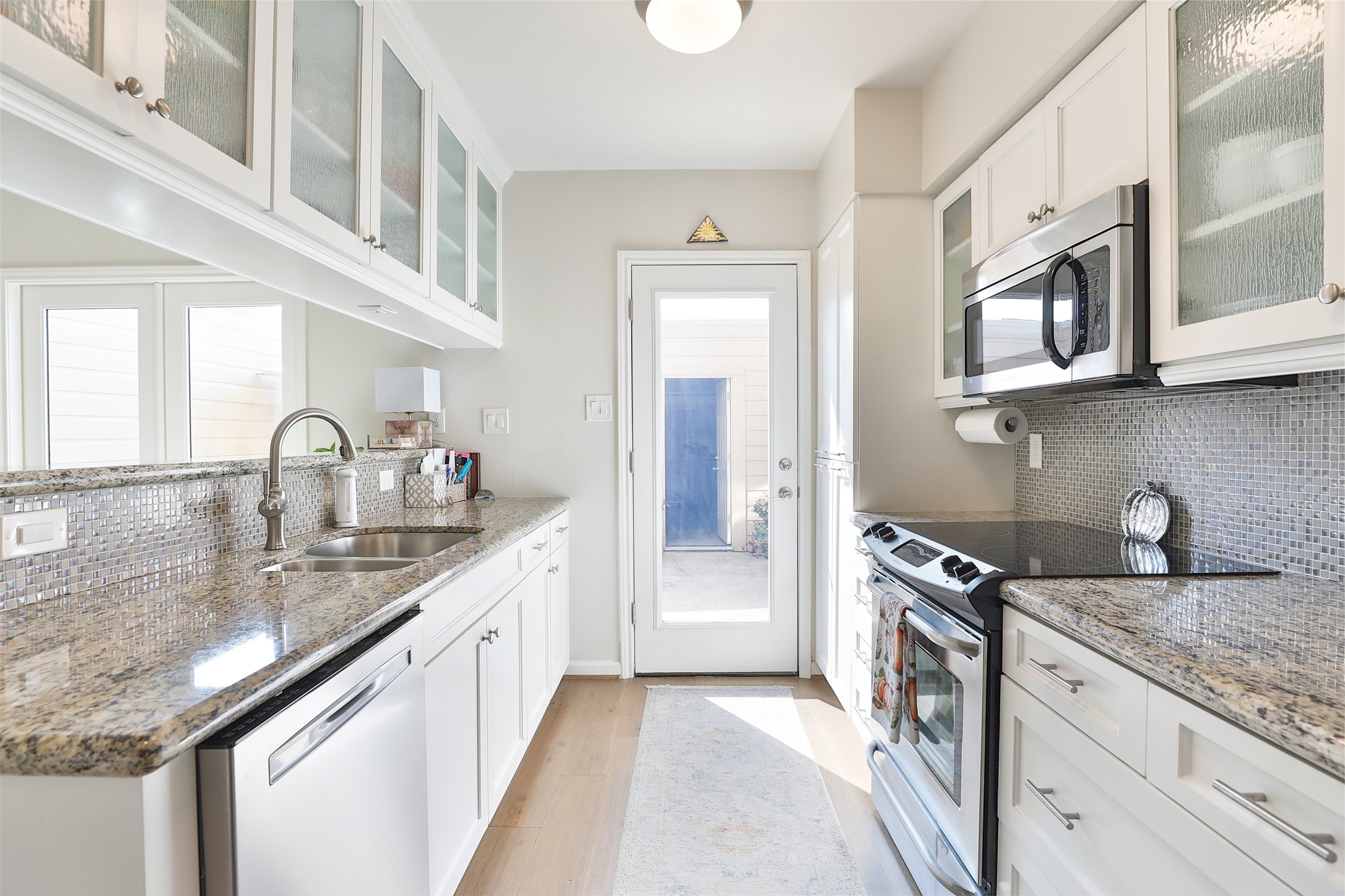 979 Memorial Village Drive, Unit 48 Houston, TX 77024 - Photo 7 of 18 a kitchen with stainless steel appliances granite countertop a sink stove and cabinets