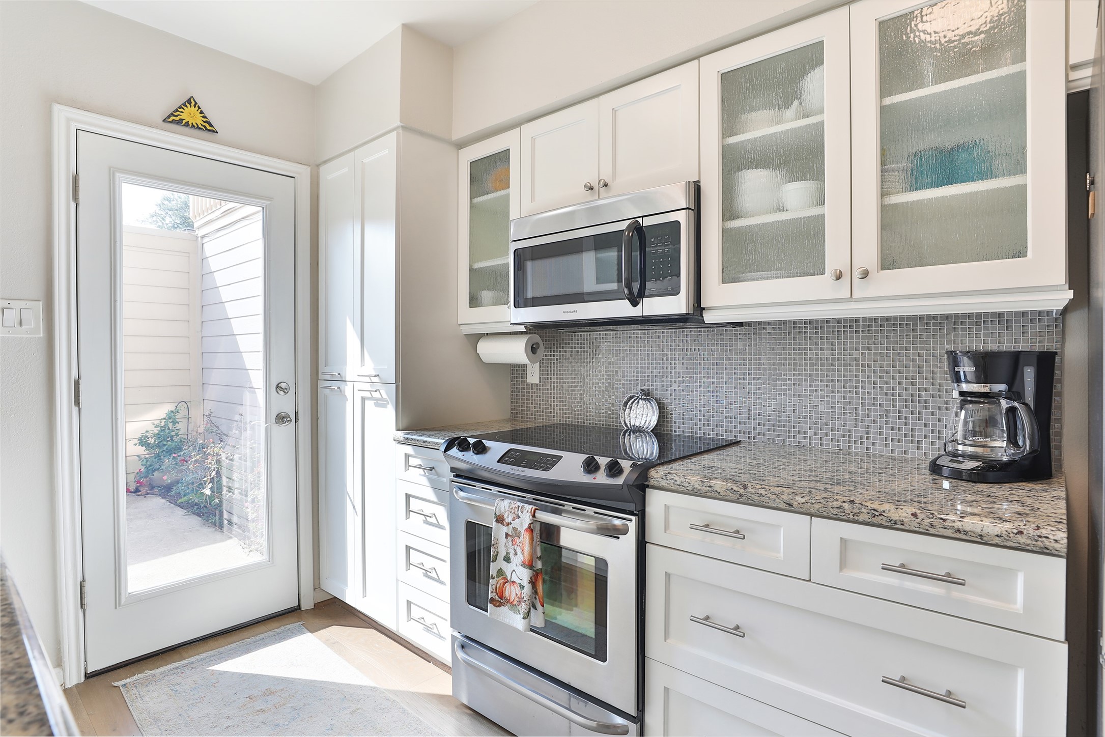 979 Memorial Village Drive, Unit 48 Houston, TX 77024 - Photo 9 of 18 a kitchen with stainless steel appliances granite countertop white cabinets and a stove