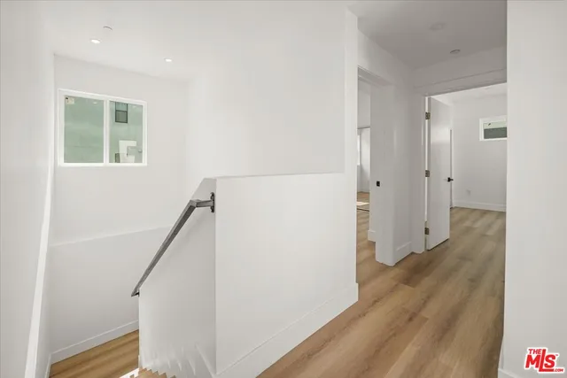 a view of a room with wooden floor and a hallway