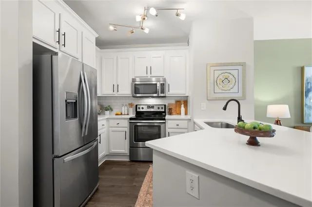 a kitchen with a refrigerator and a stove top oven