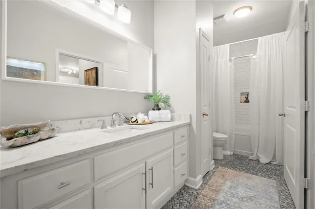a spacious bathroom with a granite countertop sink and a mirror