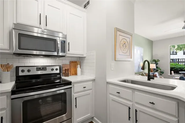 a kitchen with stainless steel appliances a stove microwave and sink