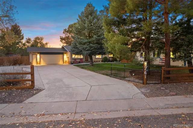 a front view of a house with a yard and tree s