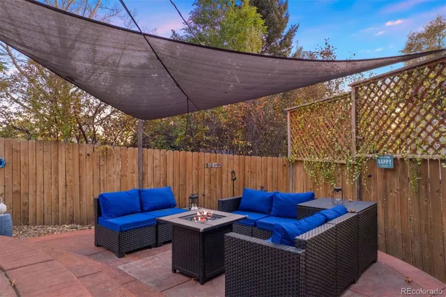 a view of backyard with outdoor seating and wooden fence