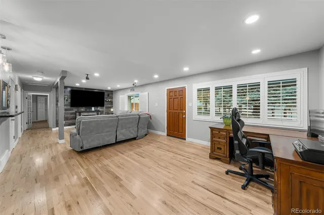 a living room with furniture floor to ceiling window and wooden floor