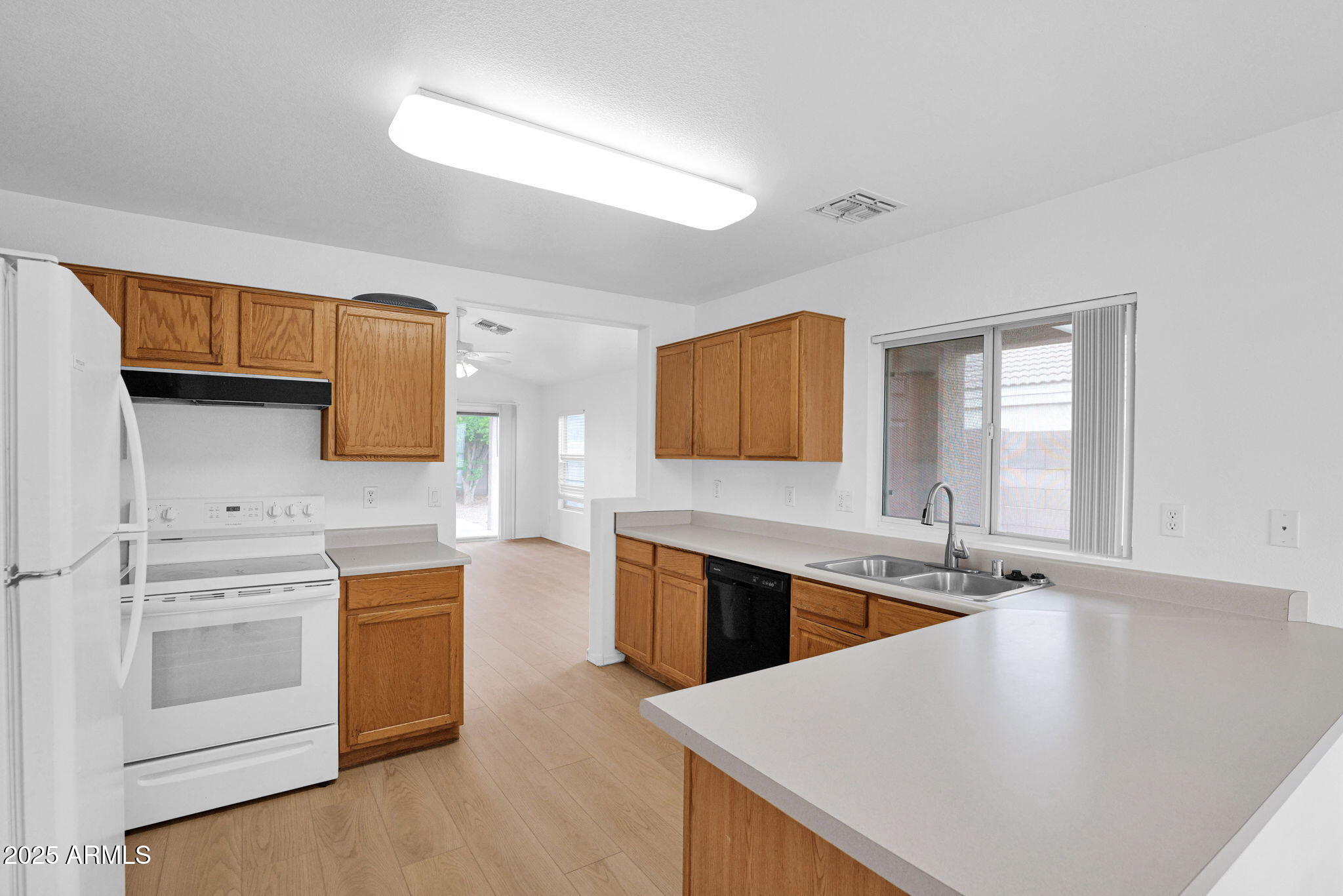 882 East Monterey Street Chandler, AZ 85225 - Photo 11 of 33 a kitchen with stainless steel appliances granite countertop a sink dishwasher stove and white cabinets with wooden floor