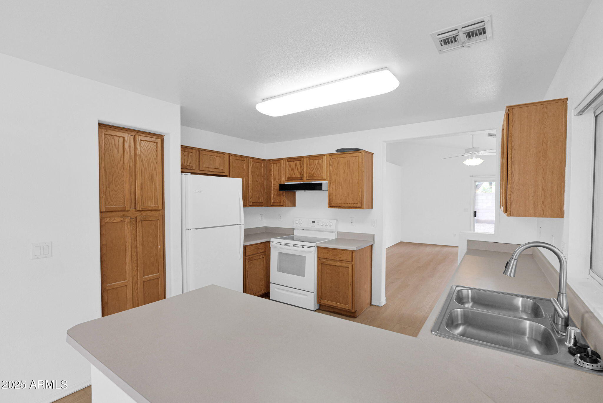 882 East Monterey Street Chandler, AZ 85225 - Photo 13 of 33 a kitchen with stainless steel appliances granite countertop a sink a stove top oven a refrigerator with white cabinets and wooden floor