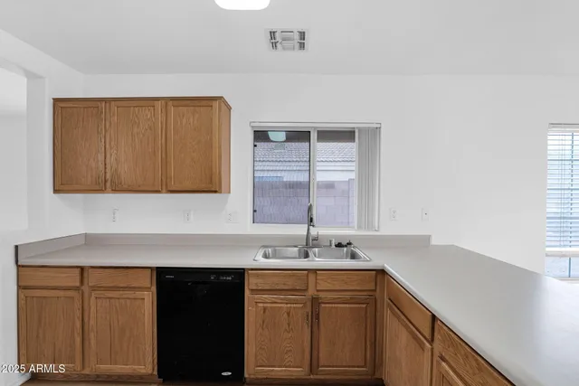 a kitchen with stainless steel appliances granite countertop a sink dishwasher stove and white cabinets with wooden floor