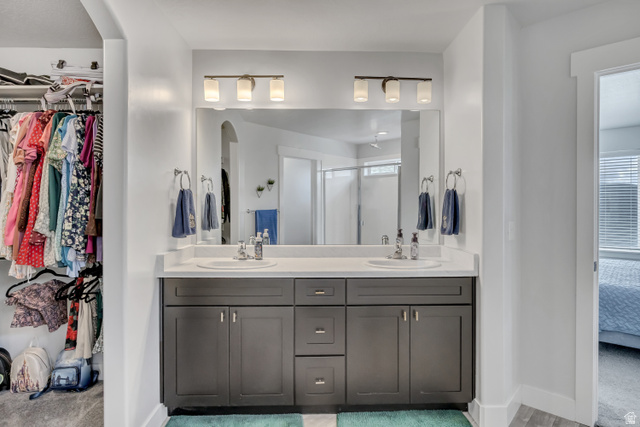 1577 Quailhill Road Saratoga Springs, UT 84045 - Photo 21 of 46 Primary bathroom featuring double vanity, a walk in closet, ensuite bath, and a shower stall