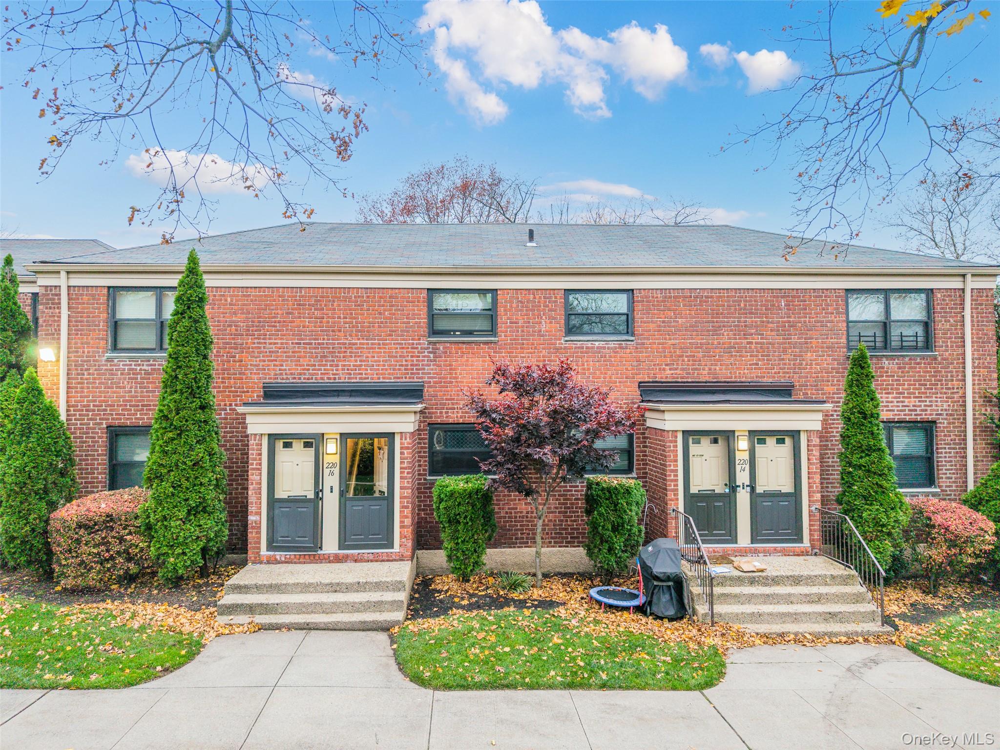 a front view of a house with a garden and plants