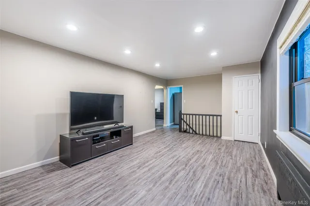 a view of a livingroom with wooden floor and a flat screen tv