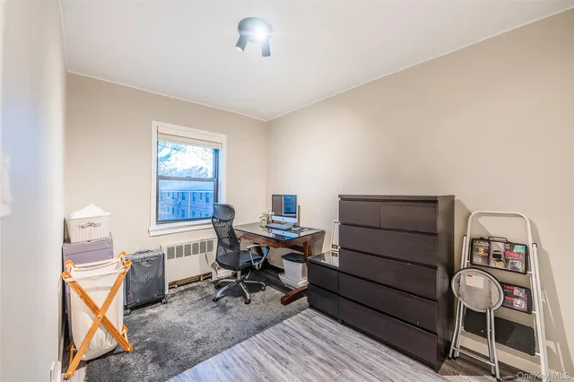 a view of a workspace with furniture and a window