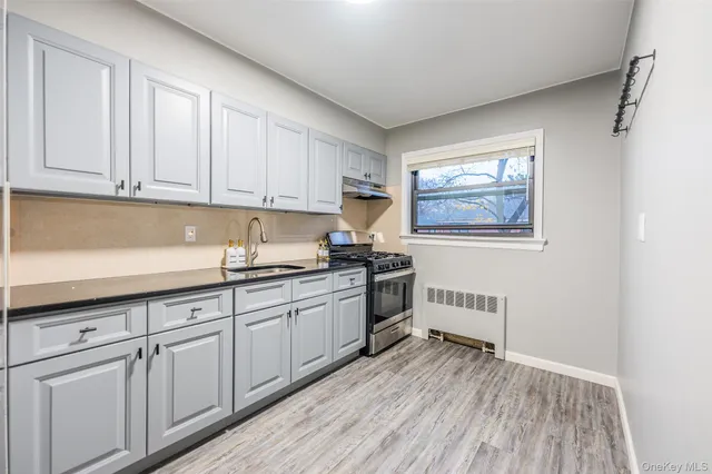 a kitchen with granite countertop white cabinets and white appliances