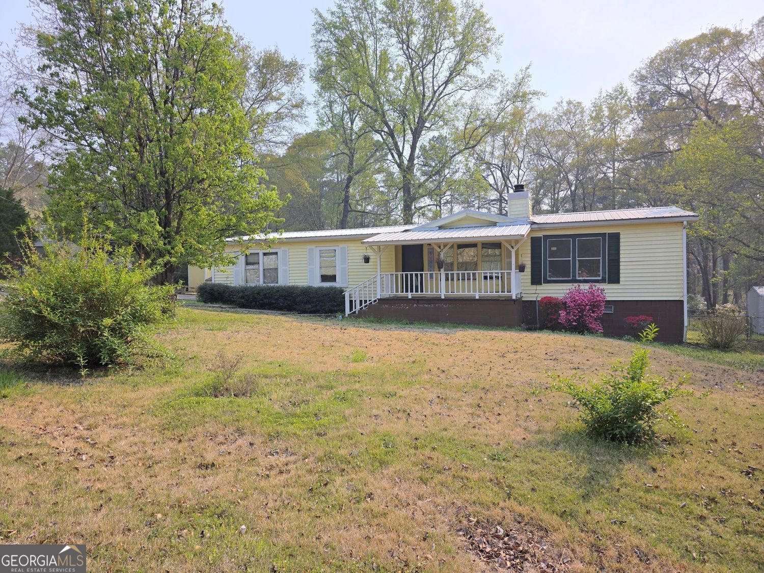 a view of a house with backyard and trees
