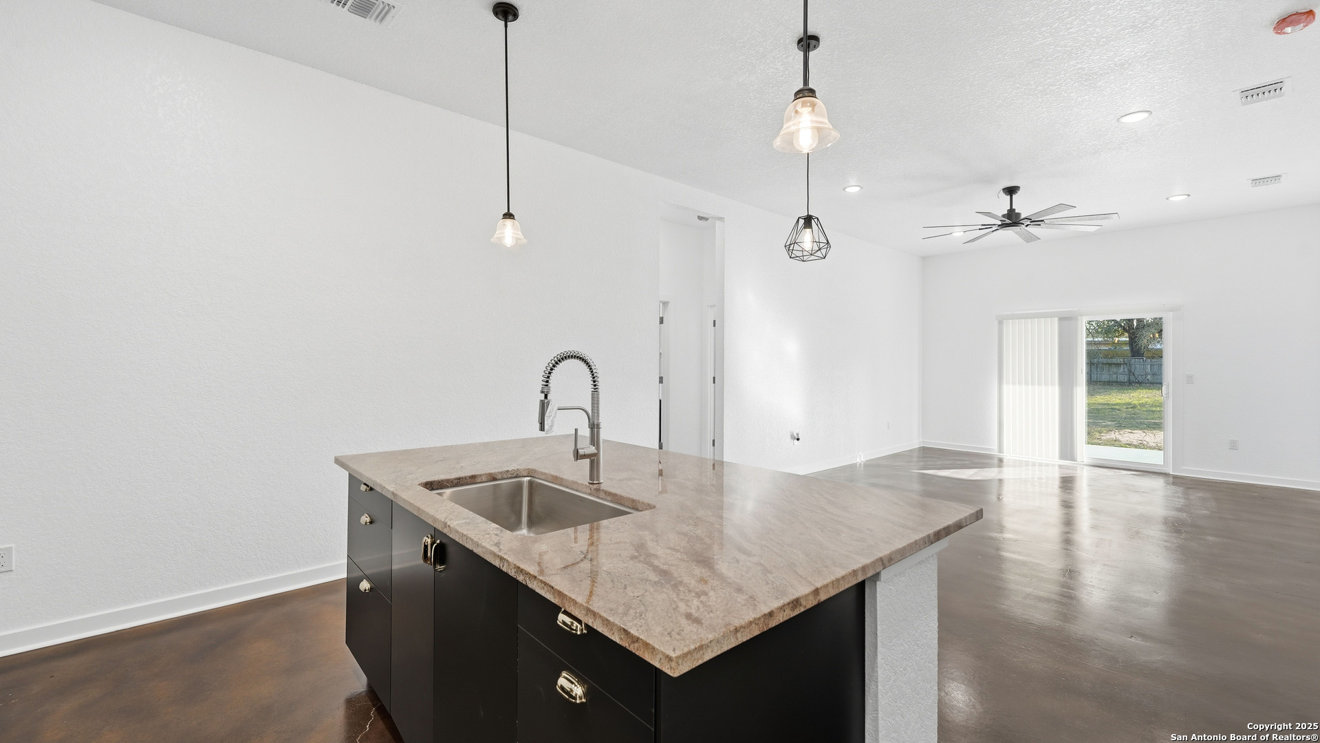 4606 Lee Way Elmendorf, TX 78112 - Photo 11 of 45 a kitchen with a sink a refrigerator and chandelier