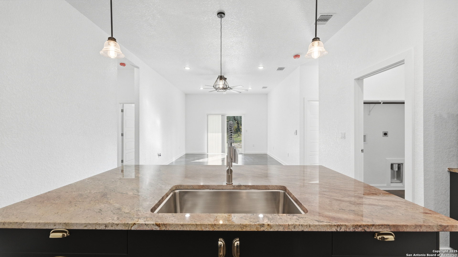 4606 Lee Way Elmendorf, TX 78112 - Photo 13 of 45 a kitchen with kitchen island a sink granite counter top and a wooden floor