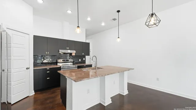 a kitchen with kitchen island a counter top space stainless steel appliances and cabinets