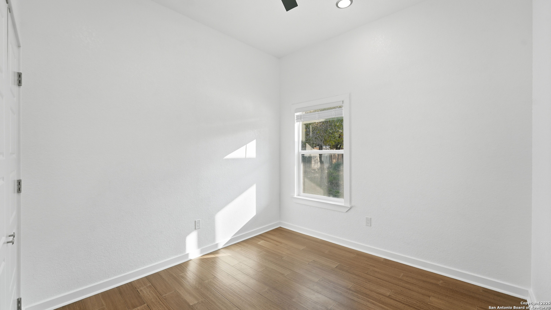 4606 Lee Way Elmendorf, TX 78112 - Photo 29 of 45 an empty room with wooden floor and windows