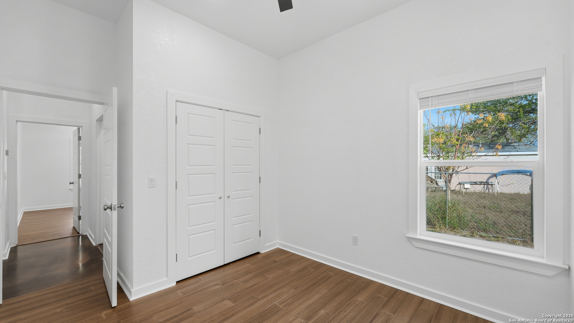 4606 Lee Way Elmendorf, TX 78112 - Photo 32 of 45 an empty room with wooden floor and a window