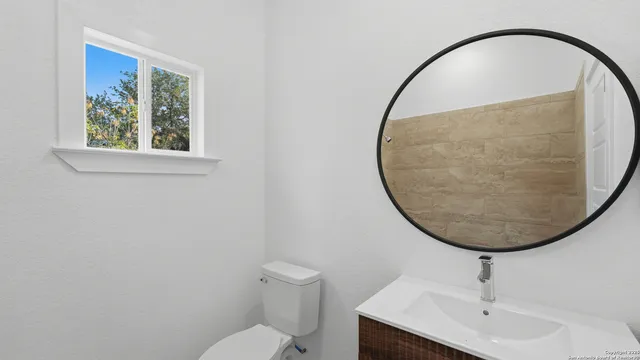 a bathroom with a sink a toilet and a mirror