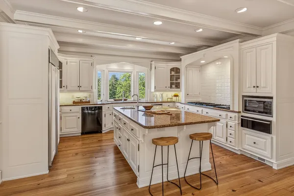 a kitchen with stainless steel appliances granite countertop a stove top oven a sink and a refrigerator