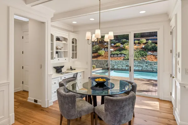 a living room with dining table and a large window