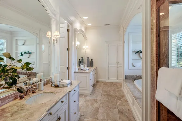 a bathroom with a tub sink and mirror