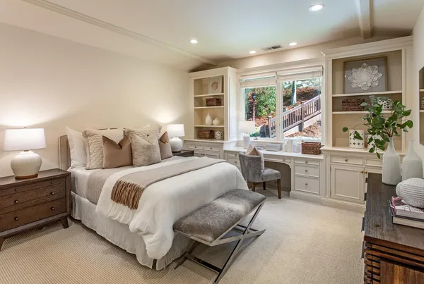 a spacious bedroom with a bed a table and chair