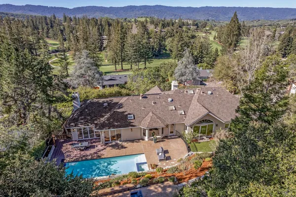 an aerial view of a house with a mountain