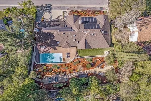 an aerial view of a house with a yard and large tree
